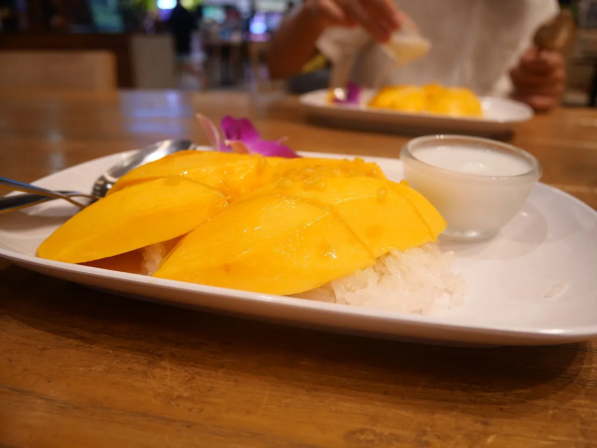 Plates of pad thai and mango sticky rice at a Thai food stall — 1