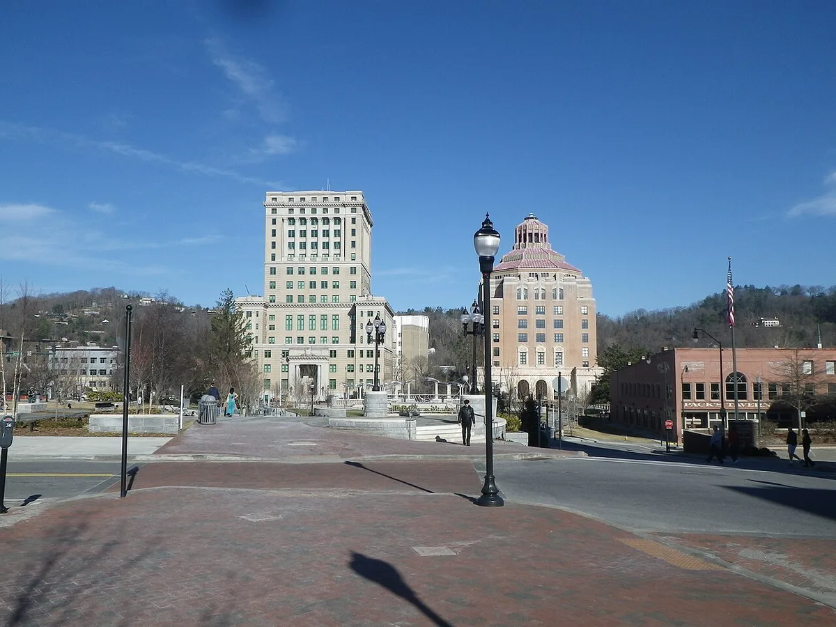 Families walking past shops and street performers in downtown Asheville, North Carolina — 1